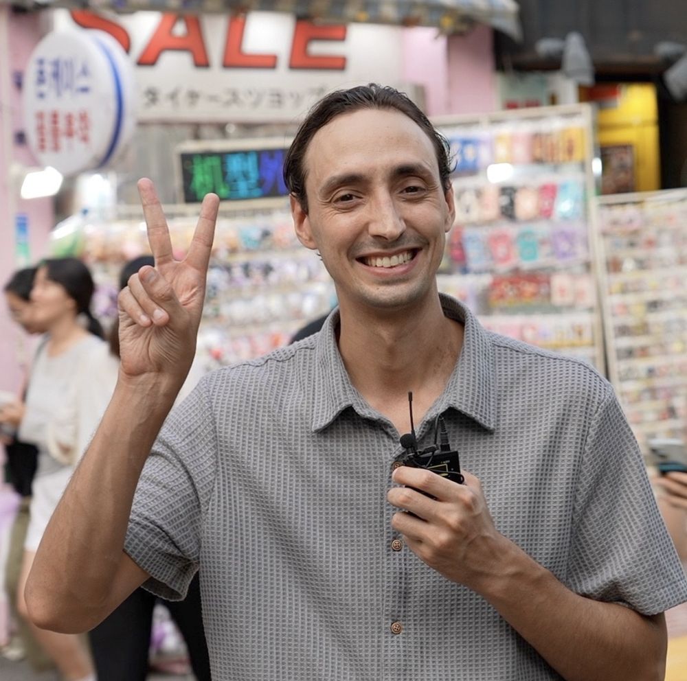 Sean holding his wireless mic on a busy Seoul shopping street