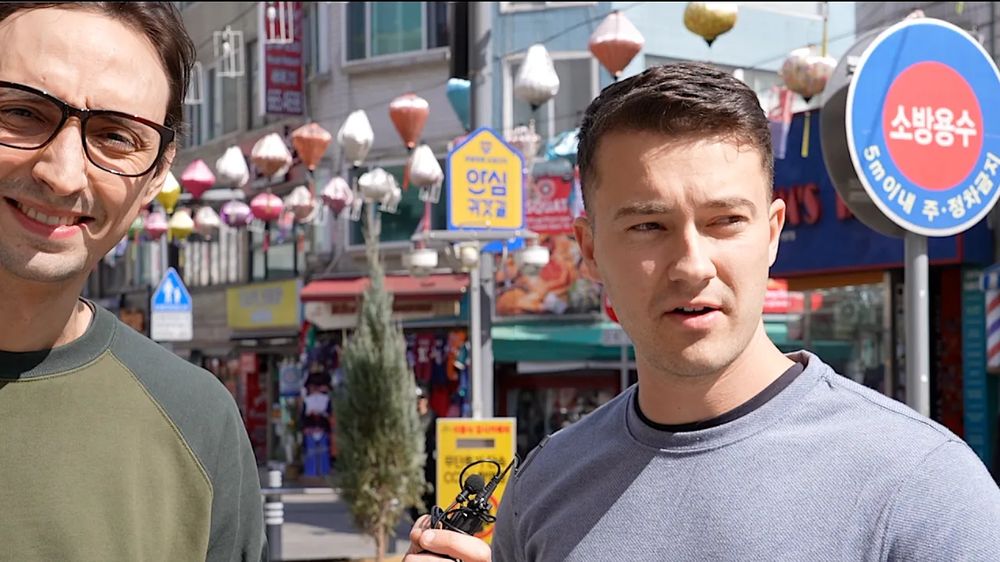 Sean interviewing a traveler on a street lined with paper lanterns